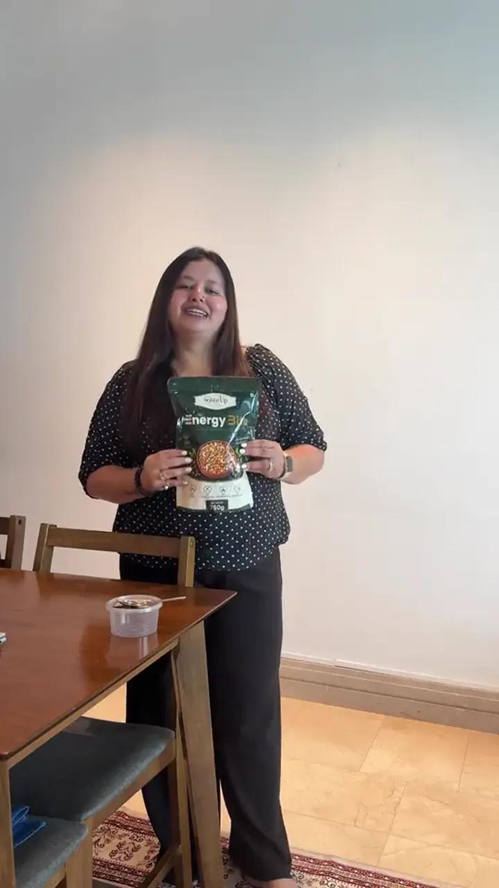 Customer holding a DiteUp Energy Bite pack at home